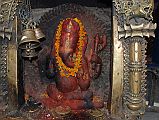 Kathmandu 05 02-3 Indra Chowk Small Ganesh Shrine A bright orange colourful brass statue of Ganesh is much visited in a small niche in Indra Chowk in Kathmandu.